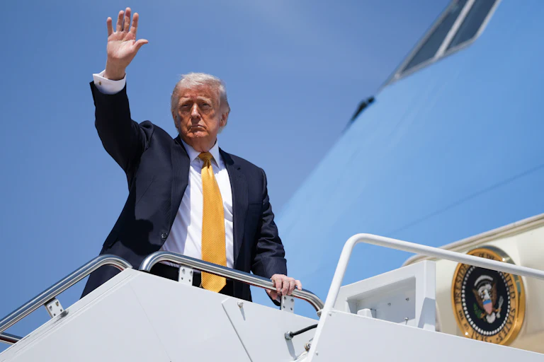 Donald Trump waves while boarding Air Force One