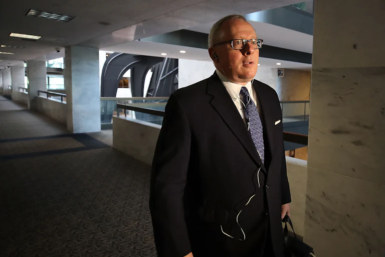 Michael Caputo walks down a hallway