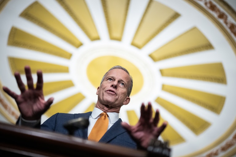 Senator John Thune gestures while speaking to reporters