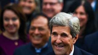John Kerry smiles in a crowd.