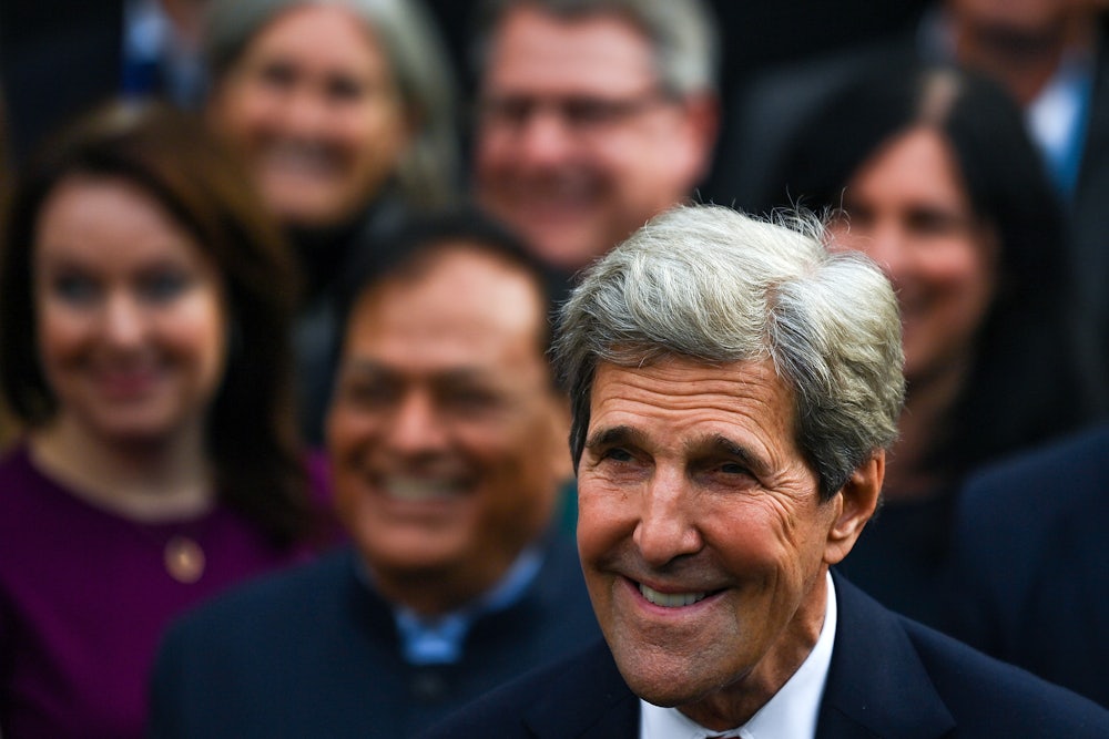 John Kerry smiles in a crowd.