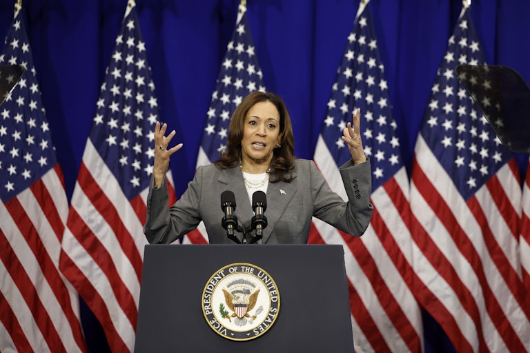 Kamala Harris gestures as she speaks into microphones