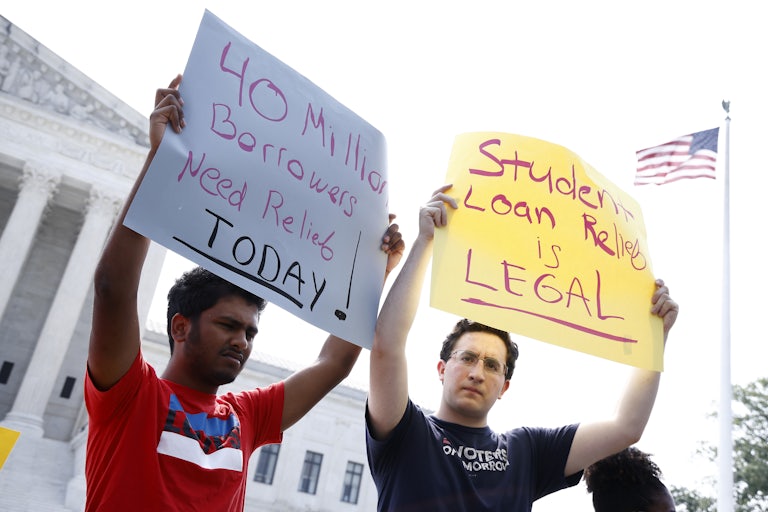 Two men hold signs in front of the Supreme Court that read "40 Million Borrowers Need Relief Today!" and "Student Loan Relief is LEGAL."