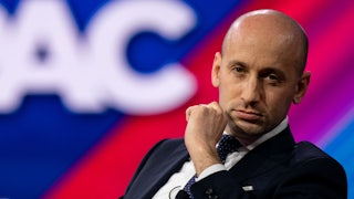 Stephen Miller holds his hand next to his face