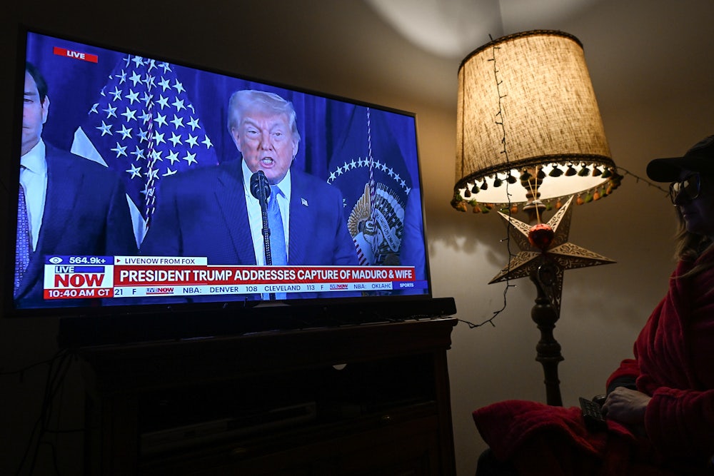 A woman watches FOX News live ahead of Donald Trump's address to the nation following a U.S. special military operation in Venezuela.