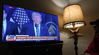 A woman watches FOX News live ahead of Donald Trump's address to the nation following a U.S. special military operation in Venezuela.