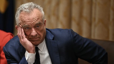 Health Secretary Robert F. Kennedy Jr. rests his cheek in his hand as he sits at a table