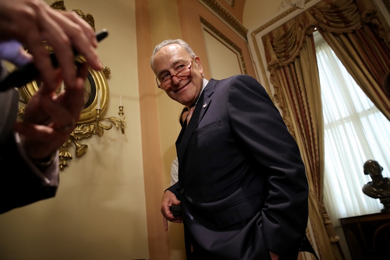Chuck Schumer smiles as he leaves a press conference.