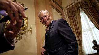Chuck Schumer smiles as he leaves a press conference.