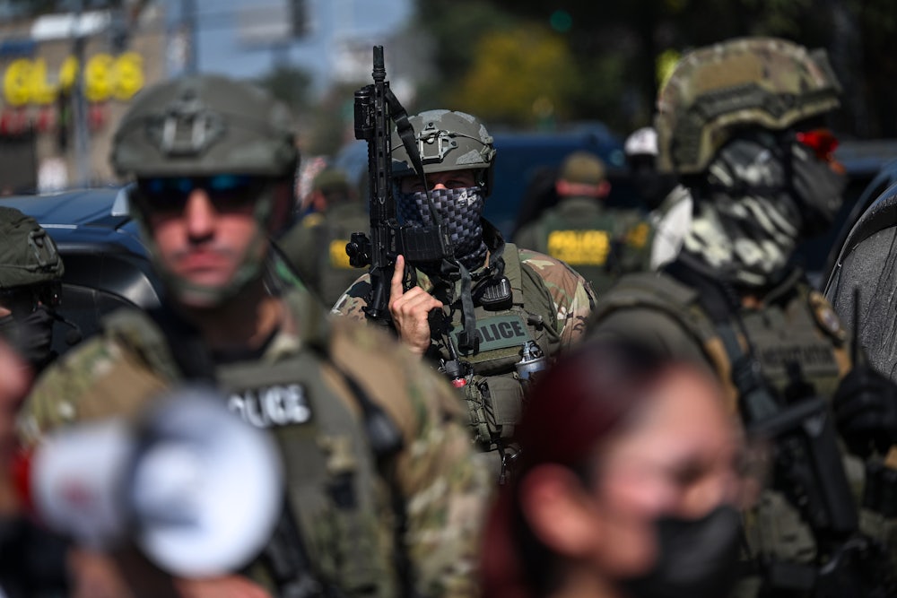 A U.S. Immigration and Customs Enforcement officer holds a rifle during a protest in Chicago.