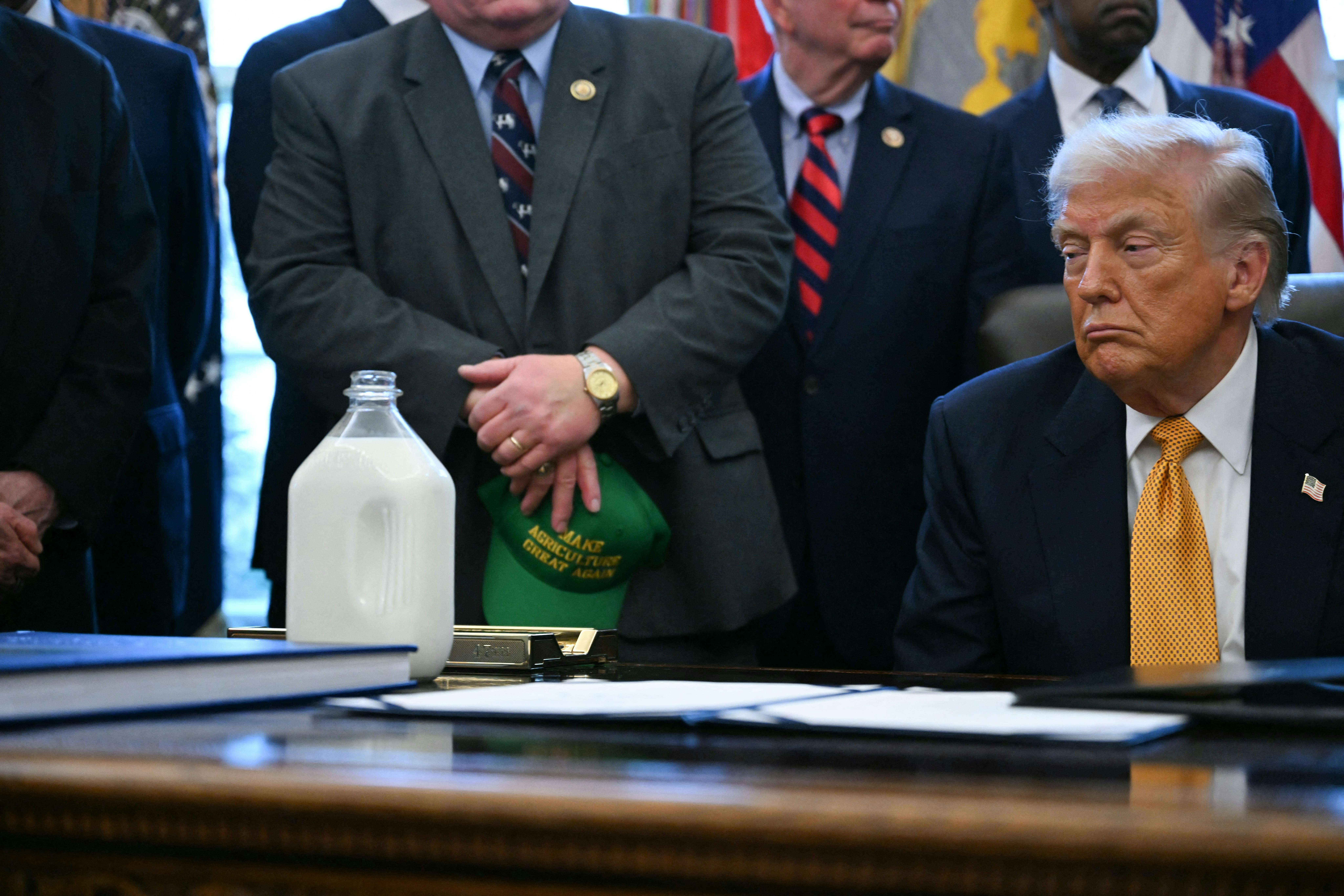 Donald Trump stares at a jug of milk on his desk in the Oval Office of the White House.