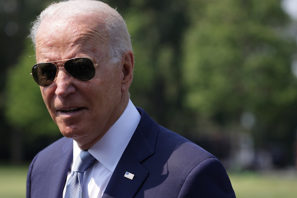 President Biden speaks to the press, wearing sunglasses.