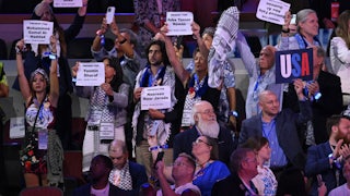 Delegates to the 2024 Democratic National Convention in Chicago, Illinois, wear keffiyehs and hold up signs with the names of people killed in Gaza.