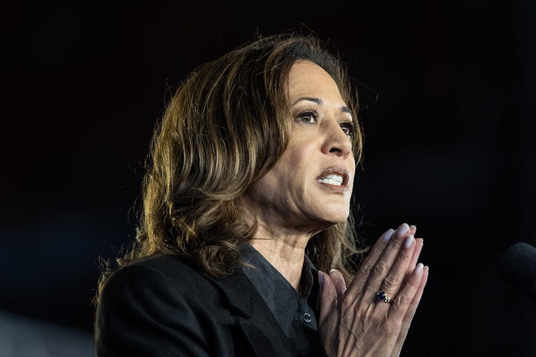 Kamala Harris presses her hands together while speaking at a campaign event