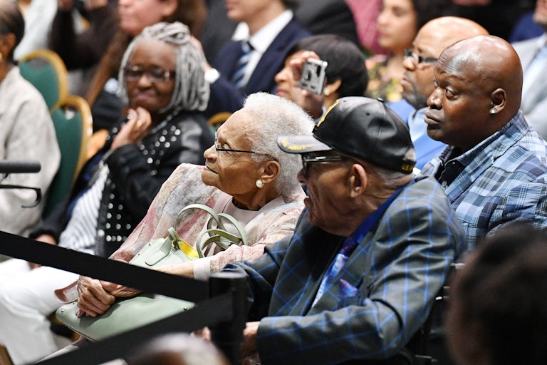 Tulsa race massacre survivors Viola Fletcher and Hughes Van Ellis sit in a crowd with other Black people