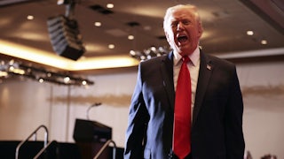 Donald Trump opens his mouth wide and speaks after leaving the stage at an event