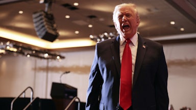 Donald Trump opens his mouth wide and speaks after leaving the stage at an event