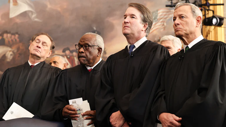 Supreme Court Justices Samuel Alito, Jr., Clarence Thomas, Brett Kavanaugh, and Chief Justice John Roberts look on during inauguration ceremonies.