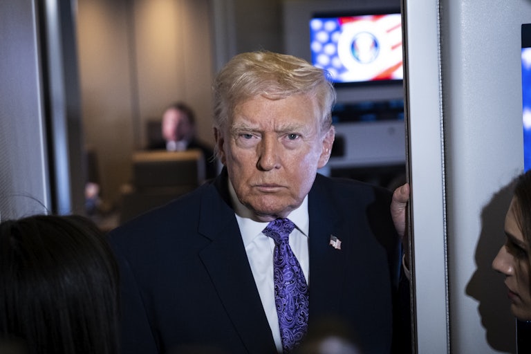 Donald Trump speaks with reporters aboard Air Force One.