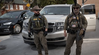 Masked federal immigration agents stand in front of a car in a neighborhood outside Chicago
