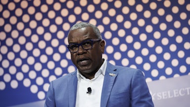 U.S. Virgin Islands Governor Albert Bryan Jr. speaks while sitting on stage during an event