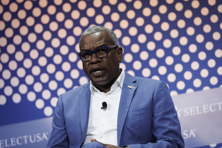 U.S. Virgin Islands Governor Albert Bryan Jr. speaks while sitting on stage during an event