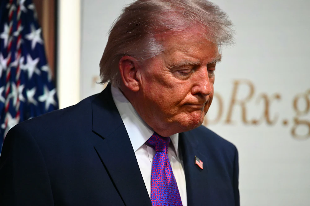 Donald Trump stares at the ground, looking downcast