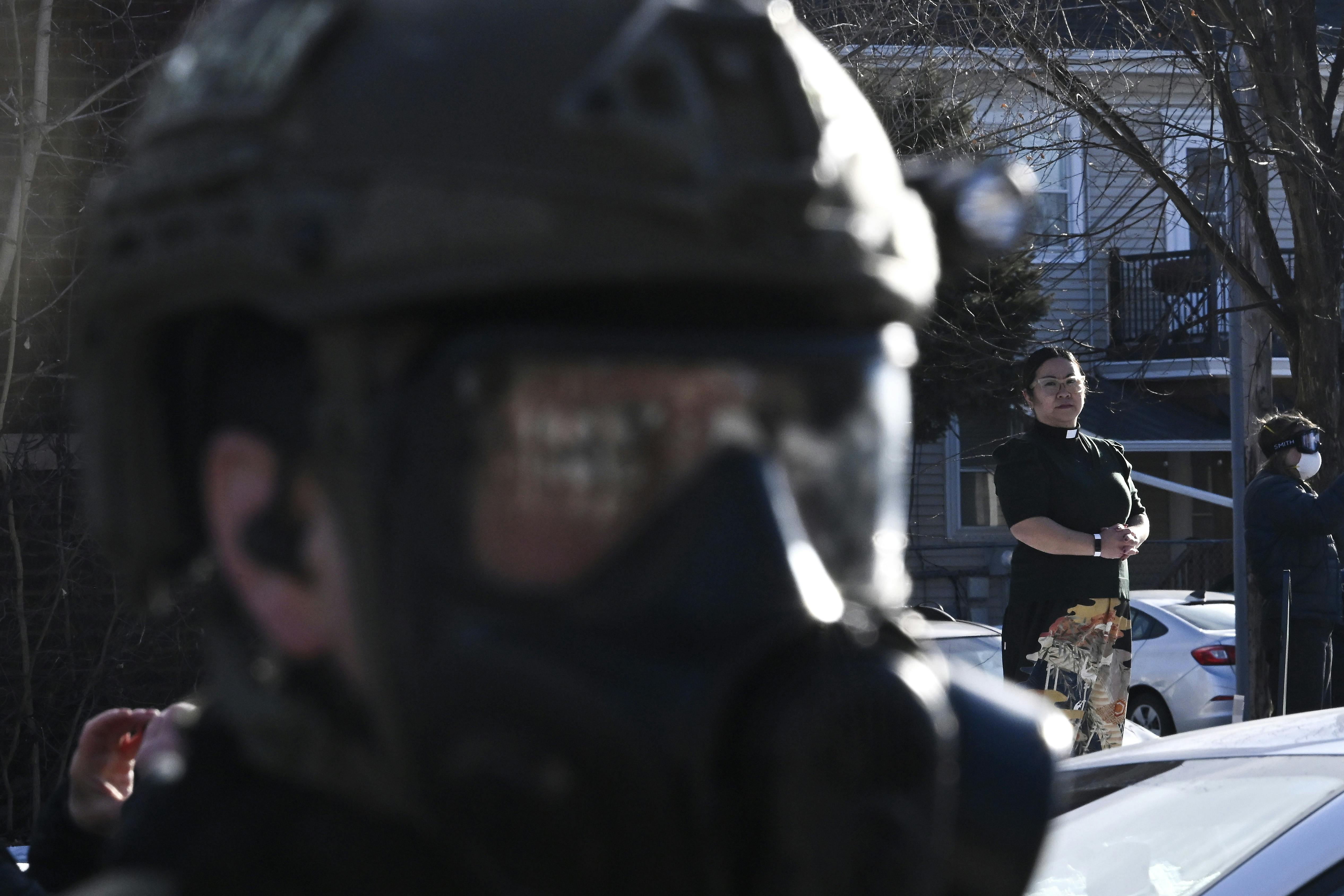 Pastor Jennifer Ikoma-Matzka from Park Ave United Methodist Church watches as ICE agents are confronted after they detained people from a residence on January 13, 2026 in Minneapolis, Minnesota.