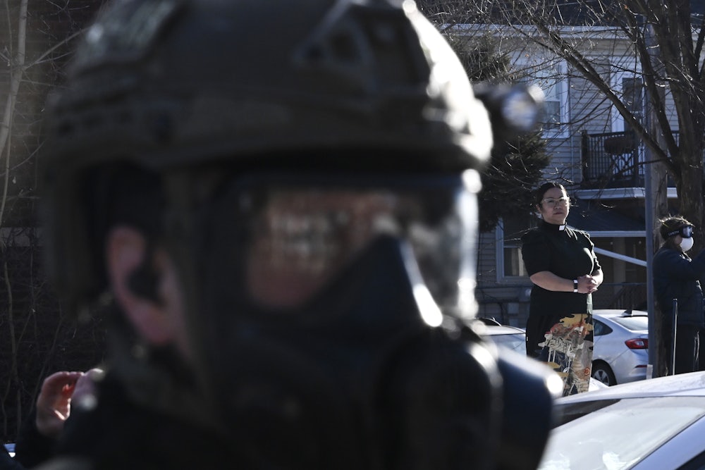 Pastor Jennifer Ikoma-Matzka from Park Ave United Methodist Church watches as ICE agents are confronted after they detained people from a residence on January 13, 2026 in Minneapolis, Minnesota.