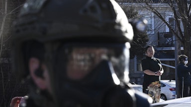 Pastor Jennifer Ikoma-Matzka from Park Ave United Methodist Church watches as ICE agents are confronted after they detained people from a residence on January 13, 2026 in Minneapolis, Minnesota.