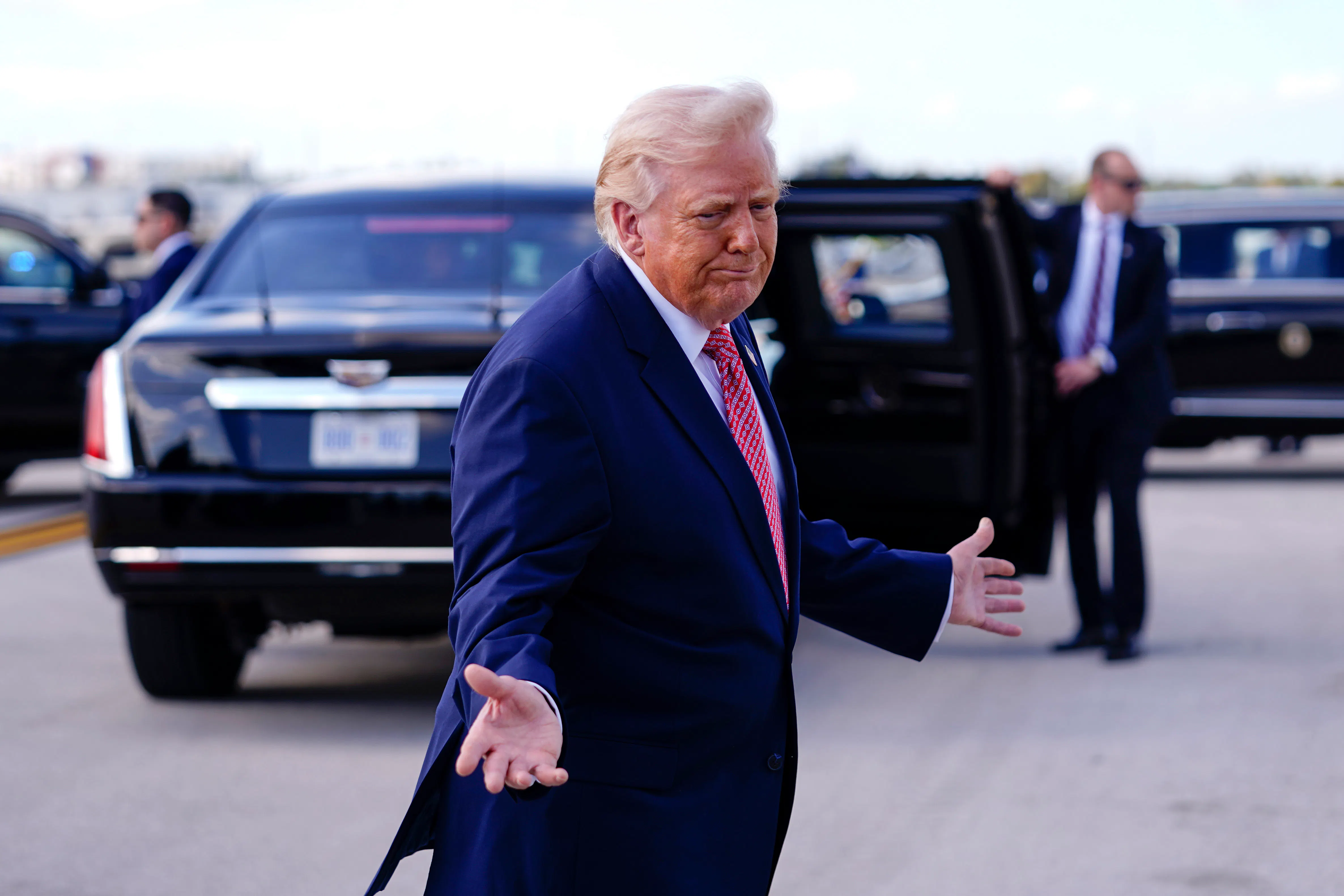 President Trump splays his hands out as if to shrug.