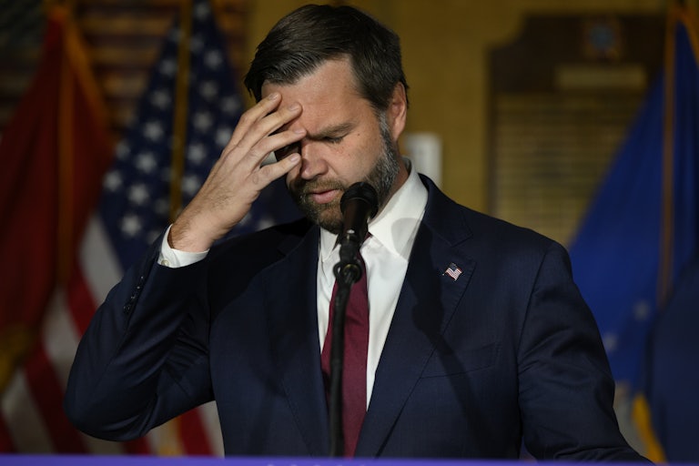 J.D. Vance touches his forehead while speaking at a Donald Trump campaign rally