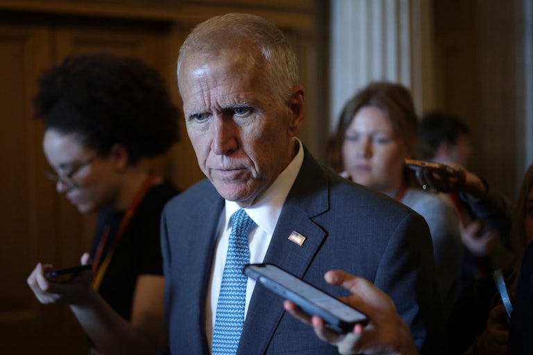 Republican Senator Thom Tillis walks and speaks to reporters in the Capitol.