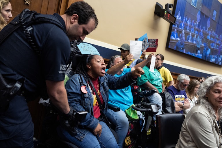 People hold up signs and call out to protest cuts to Medicaid during a House Energy and Commerce Committee hearing