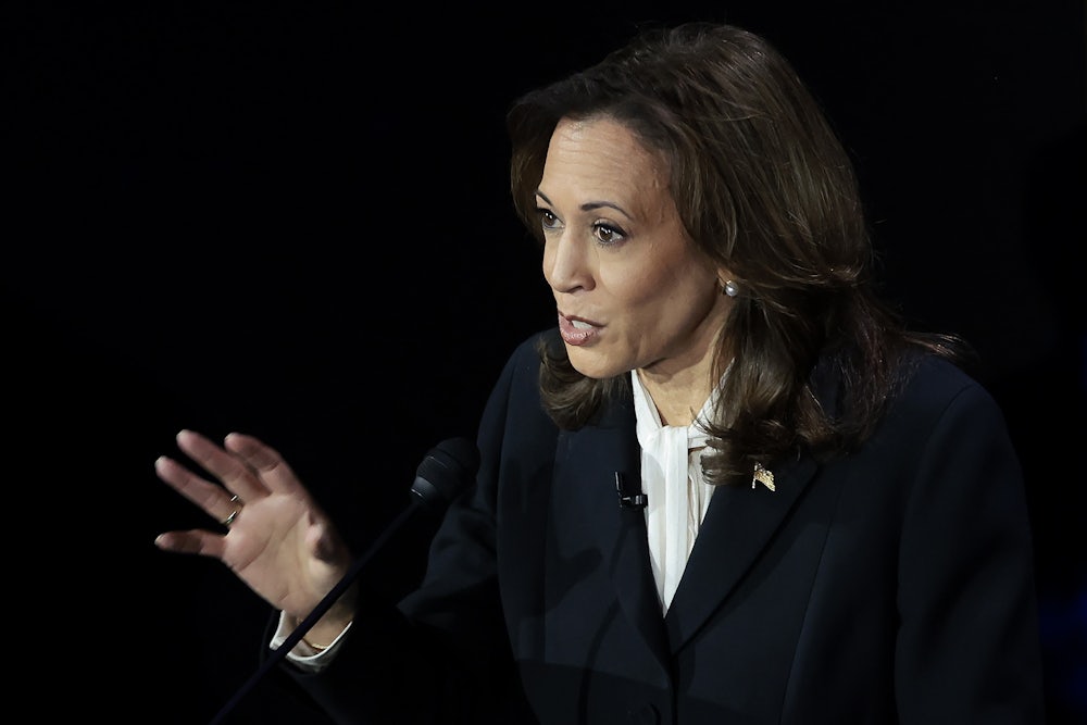 Kamala Harris holds one hand up while talking.