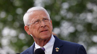 Senator Roger Wicker stands in front of two mics