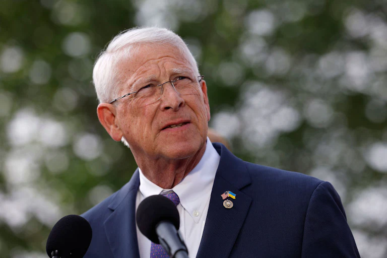 Senator Roger Wicker stands in front of two mics