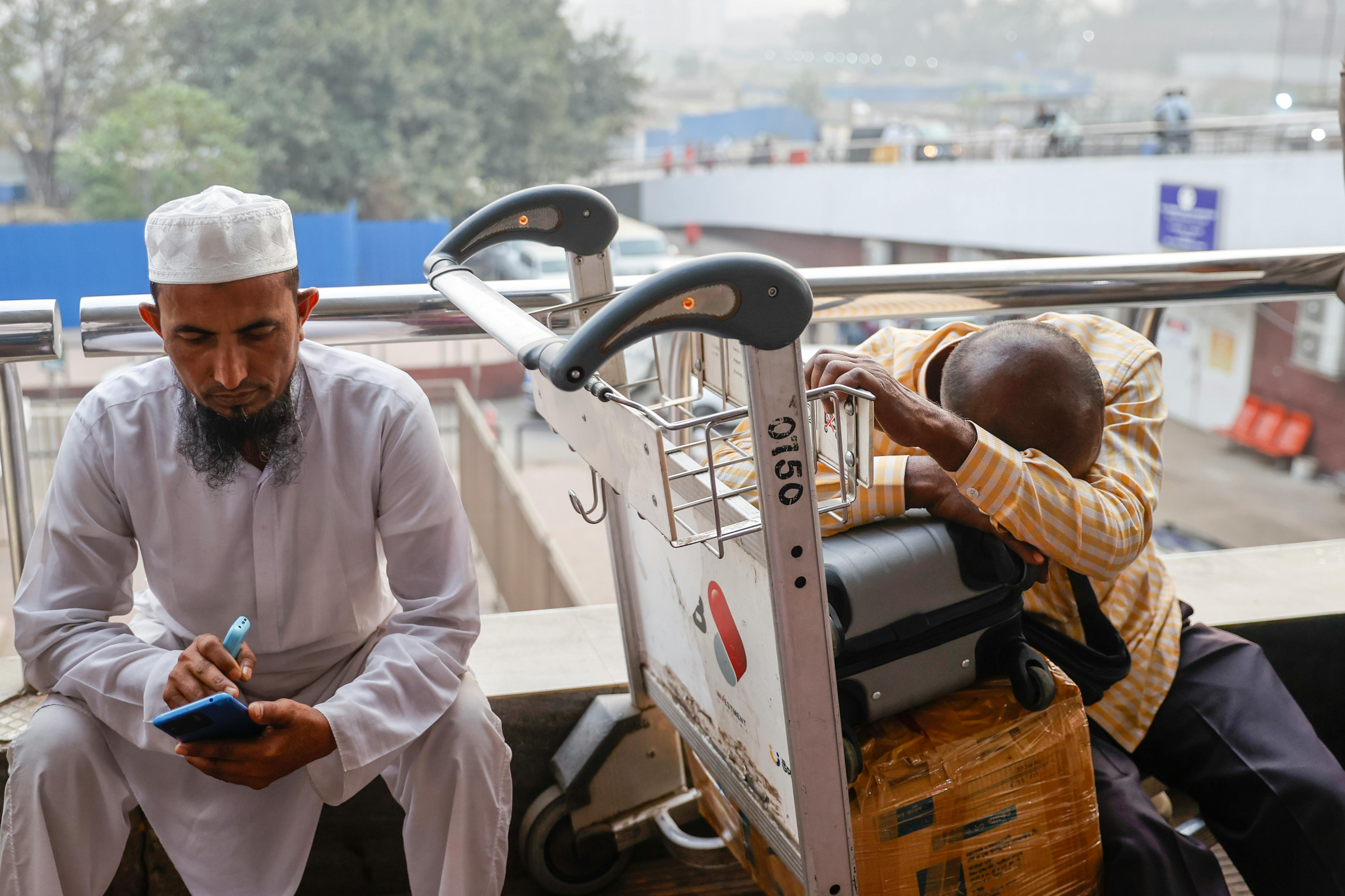 People wait outside the terminal of Hazrat Shahjalal International Airport in Dhaka, Bangladesh