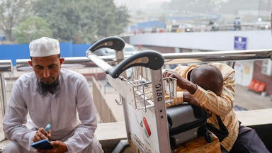 People wait outside the terminal of Hazrat Shahjalal International Airport in Dhaka, Bangladesh