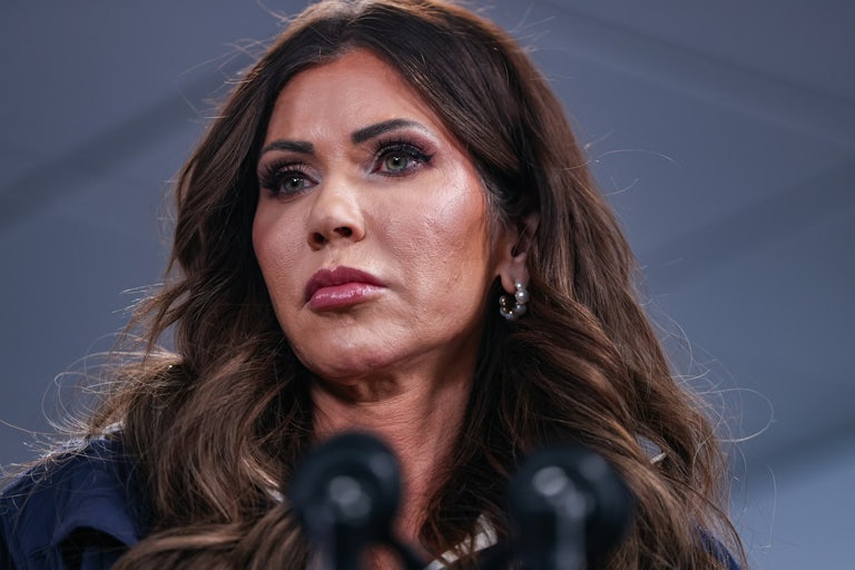 Homeland Secretary Kristi Noem stands at a microphone.