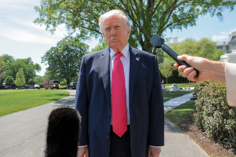 President Donald Trump speaks with reporters outside the White House