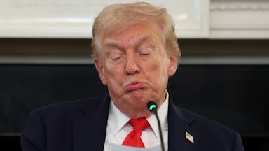 Donald Trump purses his lips and puffs his cheeks out, making a stupid face as he reads from a paper