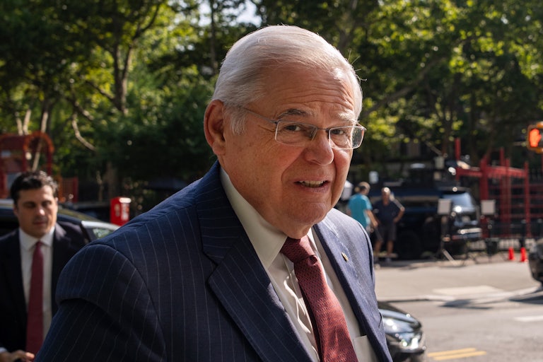 Bob Menendez looks to the side as he walks outside the courthouse for his corruption trial