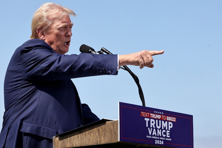 Donald Trump points while speaking into a microphone during a press conference