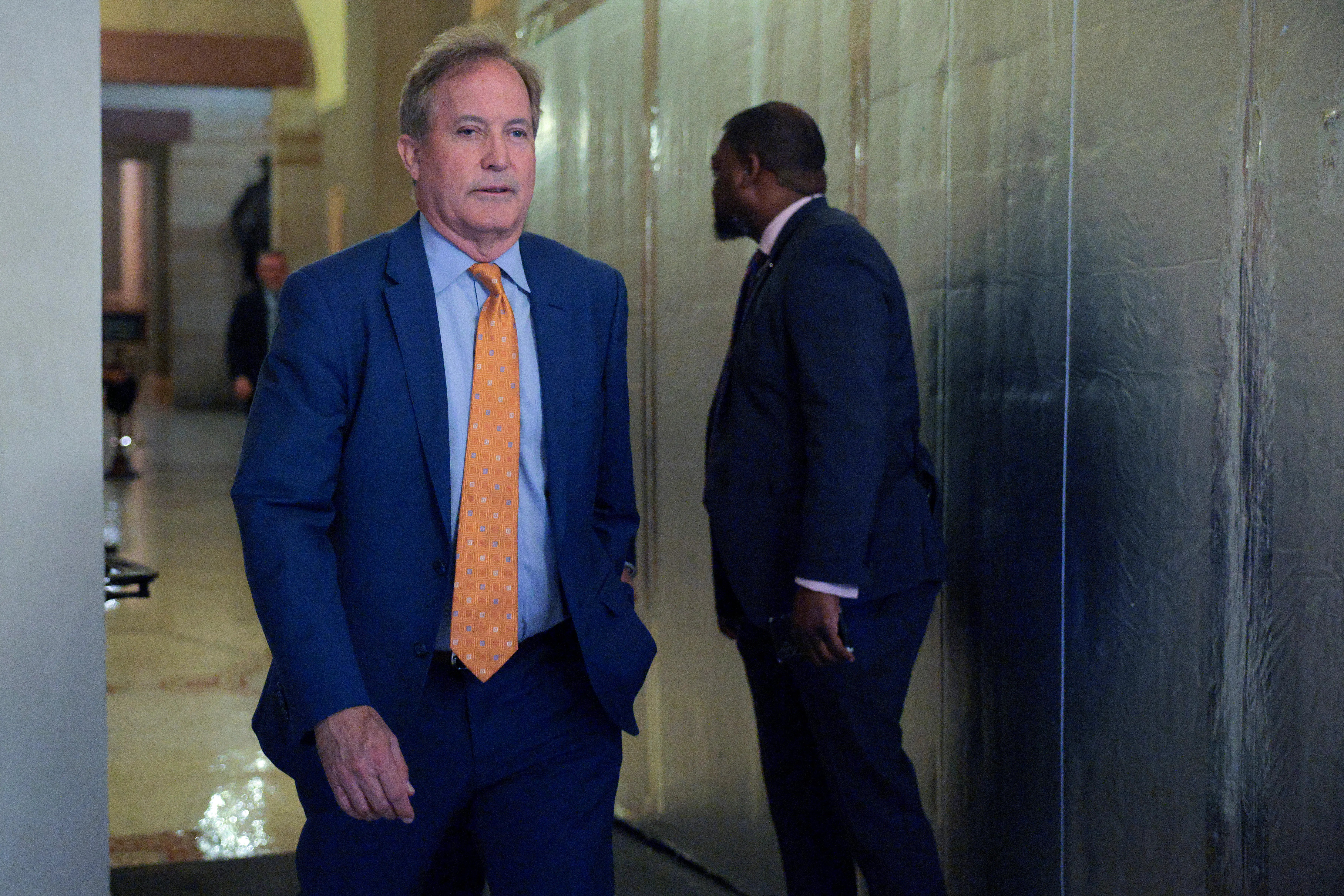 Texas Attorney General Ken Paxton walks in the Capitol