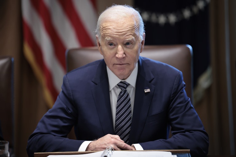 Joe Biden sits with his hands folded