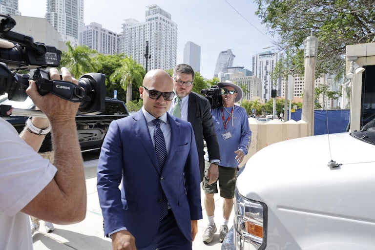 Walt Nauta walks to court as journalists with cameras surround him