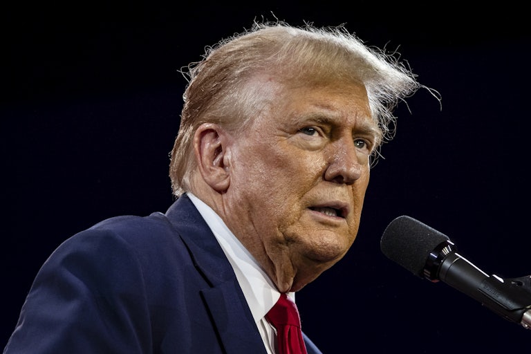 Donald Trump speaks at a mic and looks concerned. You can see the outline of his spray tan on his face. (He looks sickly.)