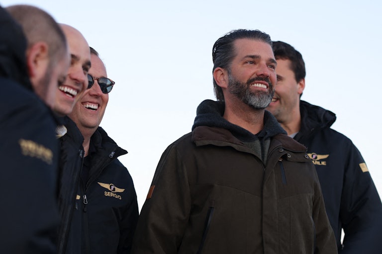 Donald Trump Jr. smiles in the cold. It's cold because he's in Greenland, where it's cold.