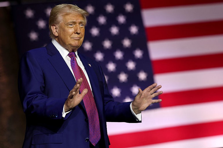 Donald Trump stands in front of a U.S. flag.